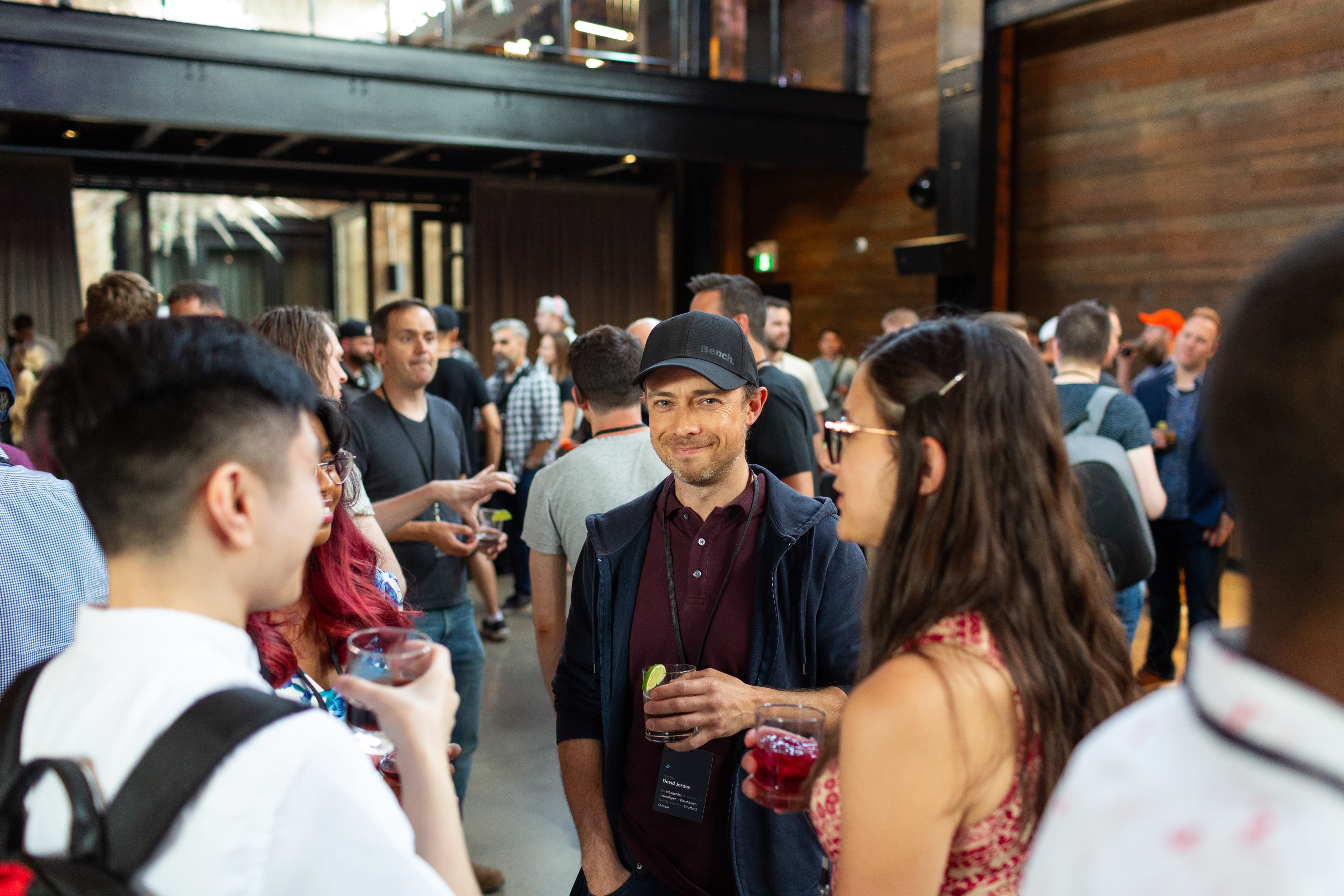 Asistentes hablando y disfrutando de bebidas antes del evento